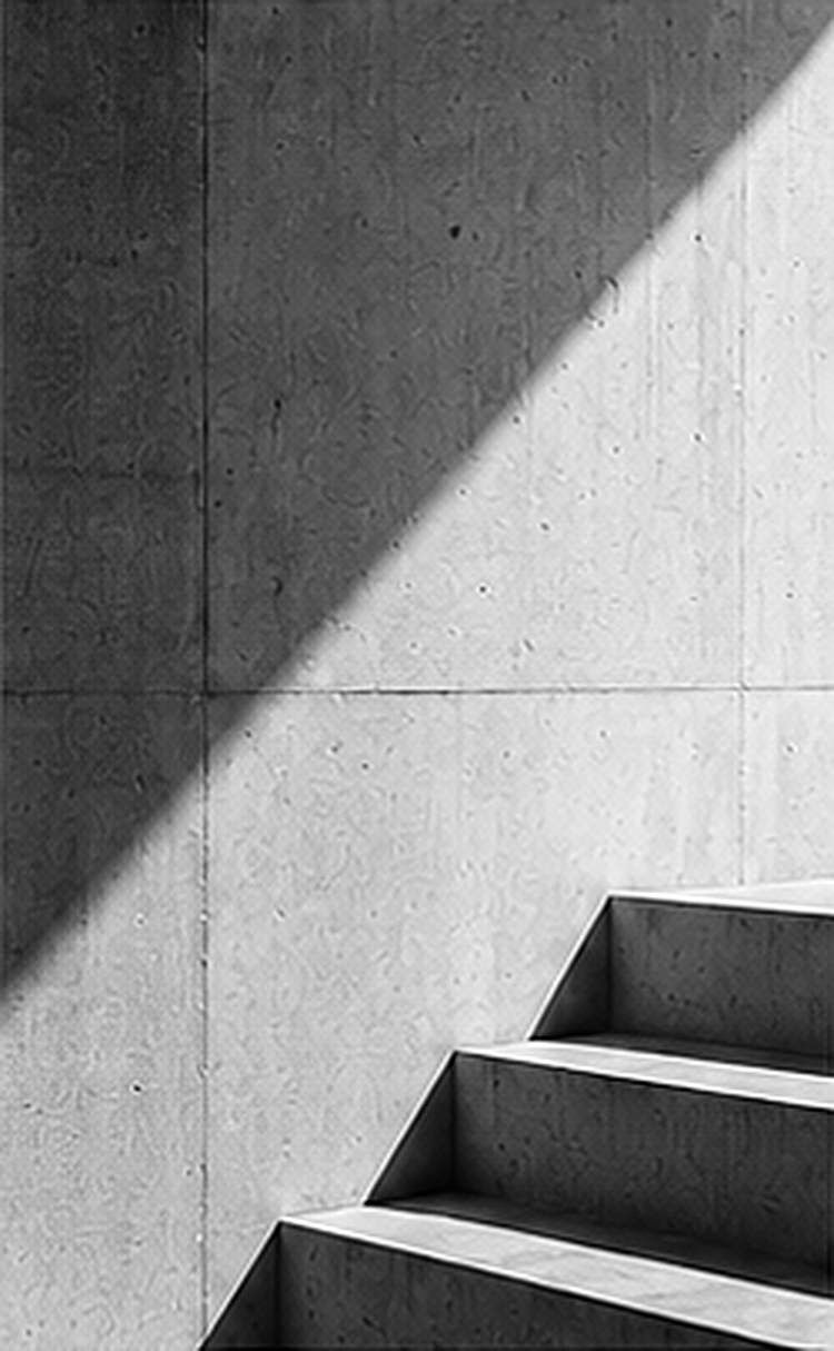 Concrete stairs rising through a diagonal shadow